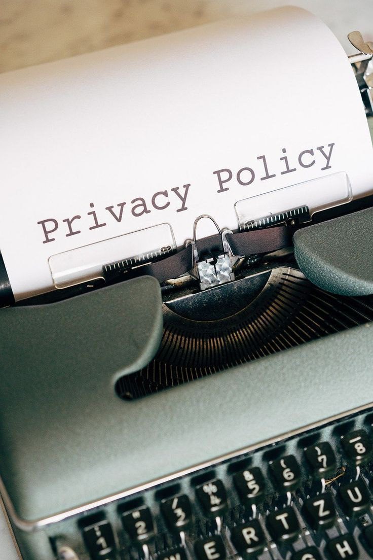 ماشین تایپ قدیمی که در حال تایپ عبارت Privacy Policy «سیاست حفظ حریم خصوصی» روی کاغذ سفید است؛ نمادی از شفافیت و صداقت در حفظ اطلاعات کاربران.